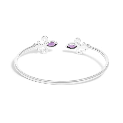 White metal open bracelet with decorative swirl ends, each featuring a purple marquise-shaped gemstone and surrounding small white round gemstones in pave setting, shown angled from above.
