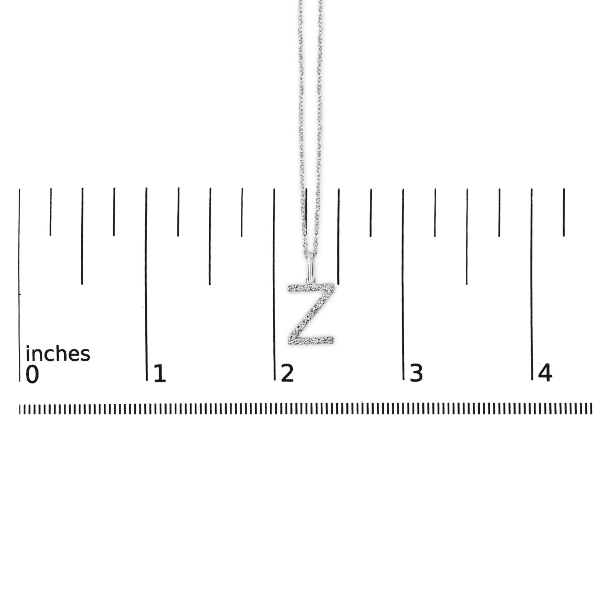 Close-up front view of a white necklace with a 'Z' shaped pendant covered in small white gemstones, shown on a ruler scale.