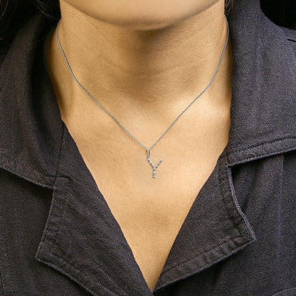 Close-up front view of a model wearing a white metal necklace with a Y-shaped pendant set with round white gemstones in a micro-pave setting.
