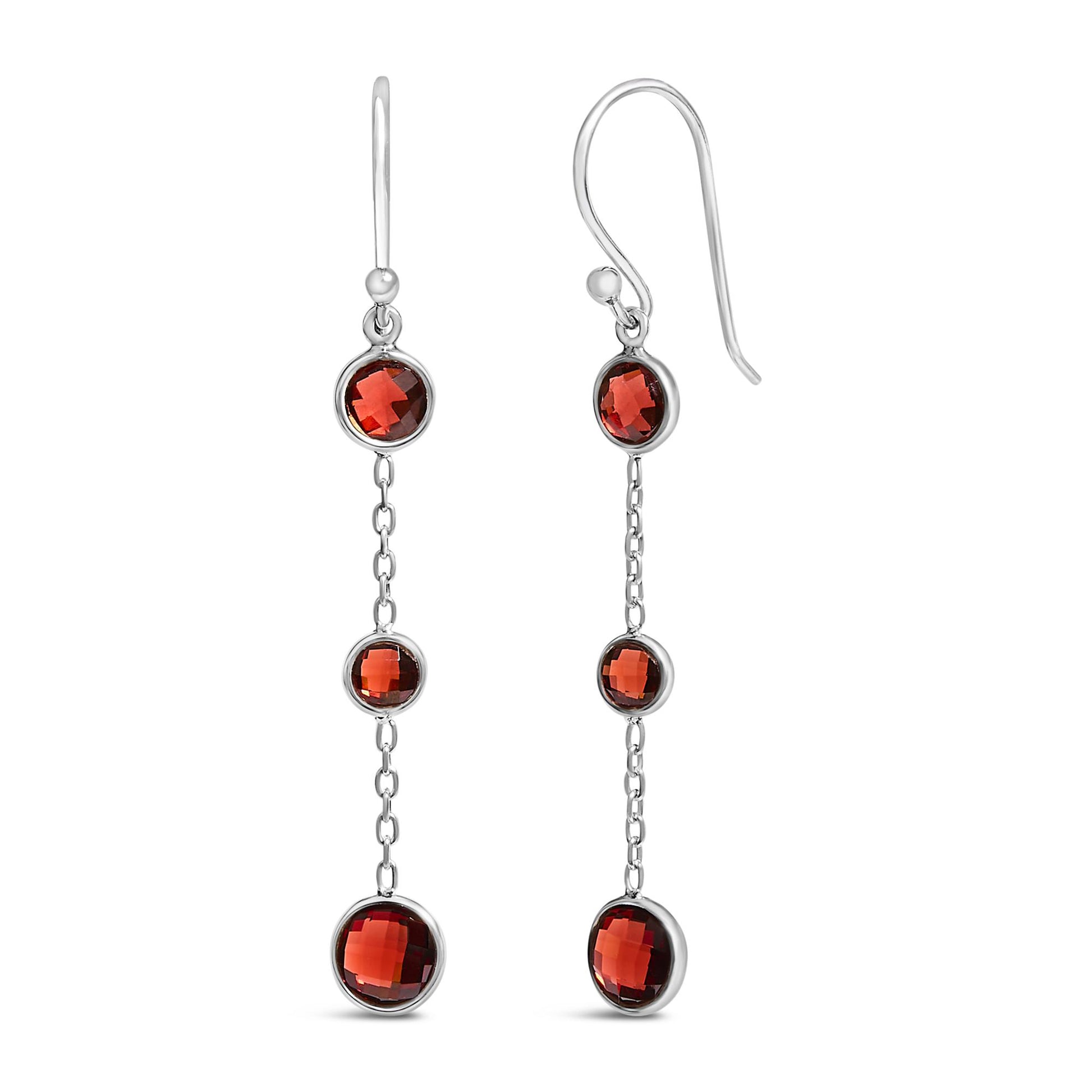 White metal drop earrings with three round red gemstones in bezel settings linked by chain sections, shown in a front-facing close-up angle.