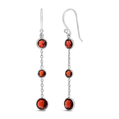 White metal drop earrings with three round red gemstones in bezel settings linked by chain sections, shown in a front-facing close-up angle.