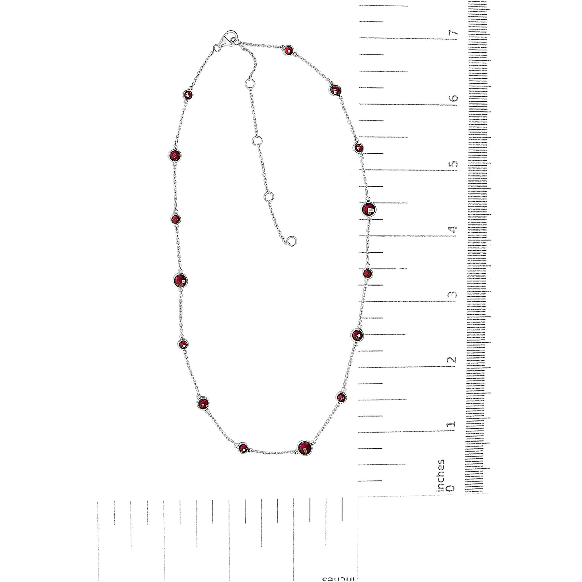White metal necklace with round red gemstones in bezel settings along the chain, displayed flat next to rulers for size reference, shot from above.