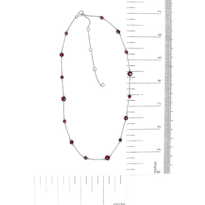 White metal necklace with round red gemstones in bezel settings along the chain, displayed flat next to rulers for size reference, shot from above.