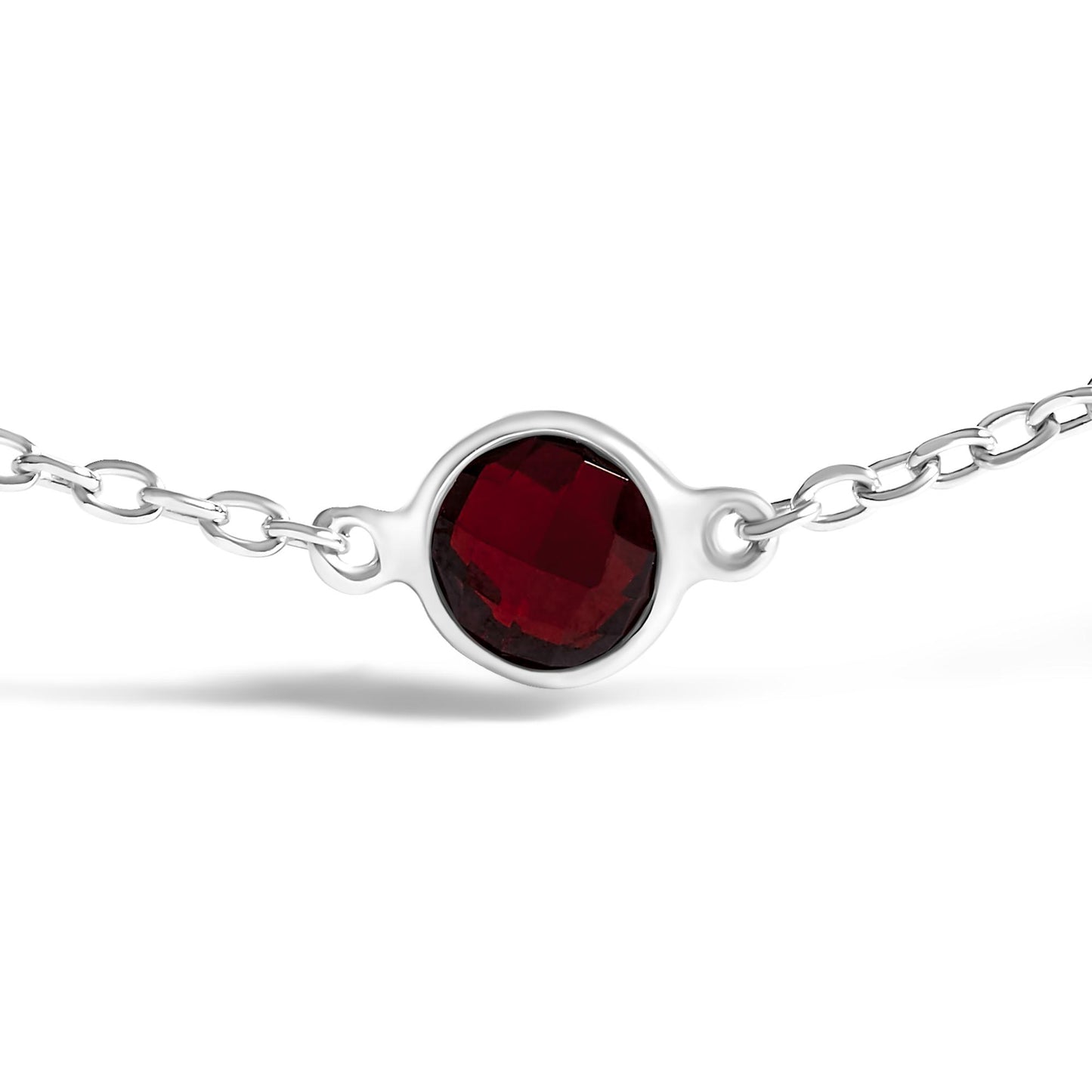 Close-up front view of a white metal bracelet featuring a round red gemstone in bezel setting on a white background.