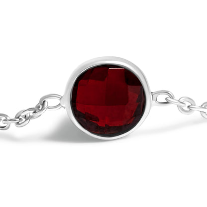 Close-up front view of a white metal bracelet with a round red gemstone in bezel setting, showing part of the chain on a white background.