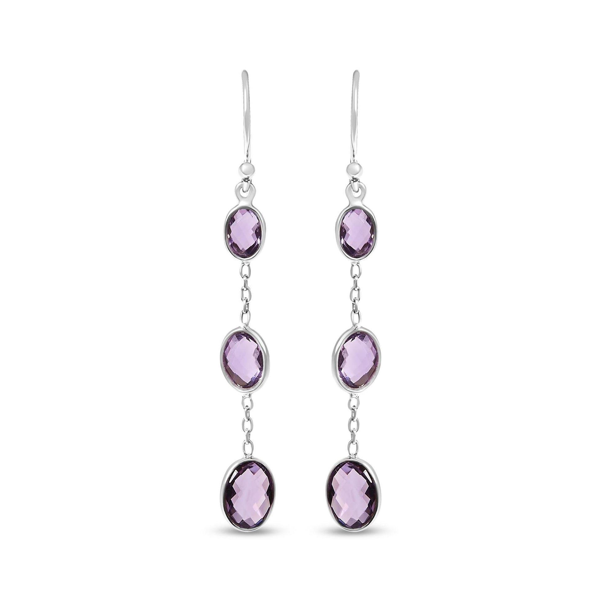 Front view of white metal dangle earrings featuring three oval purple gemstones in bezel settings connected by small links.