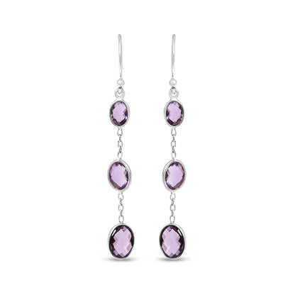 Front view of white metal dangle earrings featuring three oval purple gemstones in bezel settings connected by small links.