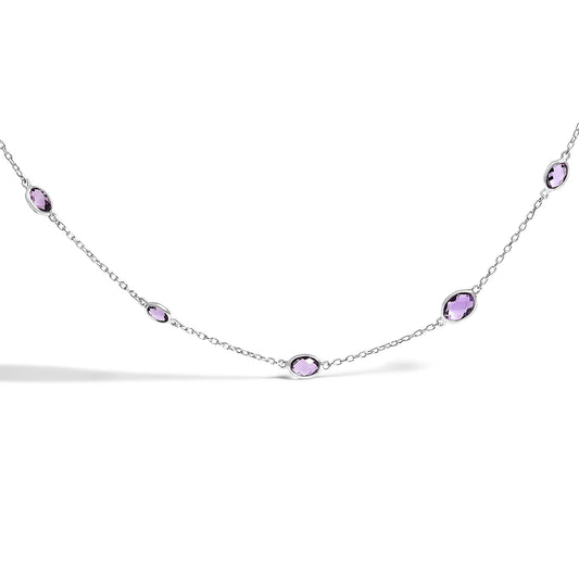 Close-up front angle of a white necklace featuring multiple purple oval bezel-set gemstones evenly spaced along a delicate chain.