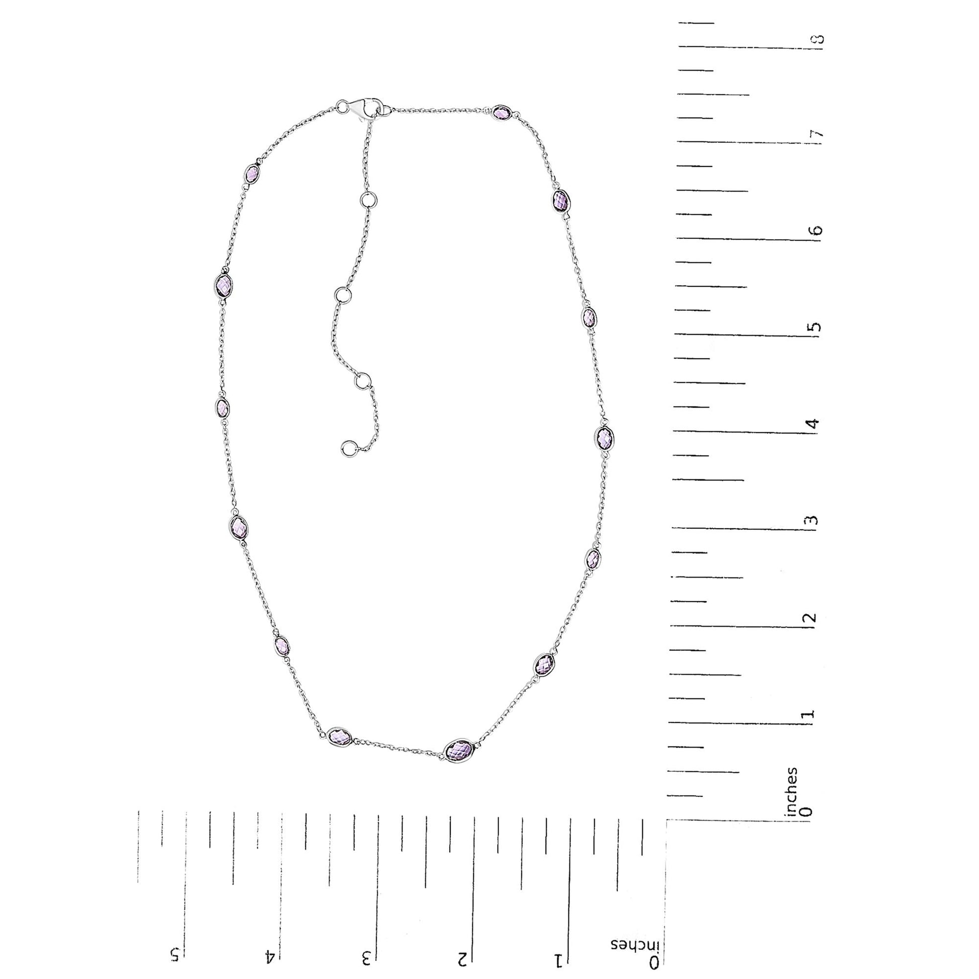 White necklace with oval purple gemstones in bezel settings evenly spaced along a fine chain, displayed flat on a white background alongside a ruler for size reference, shot from above.