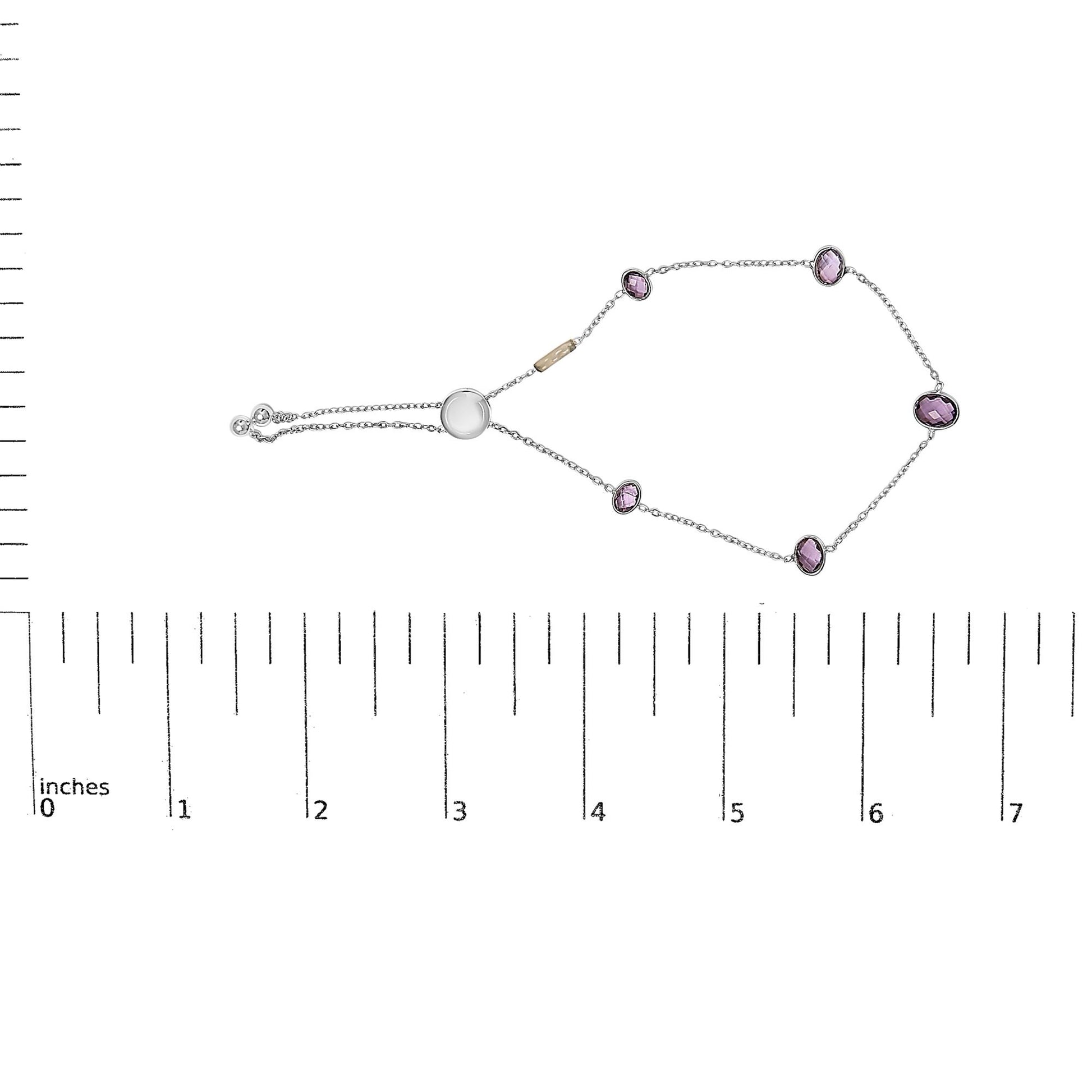 White metal bracelet with oval purple gemstones in bezel settings, displayed flat on a ruler shot from above.