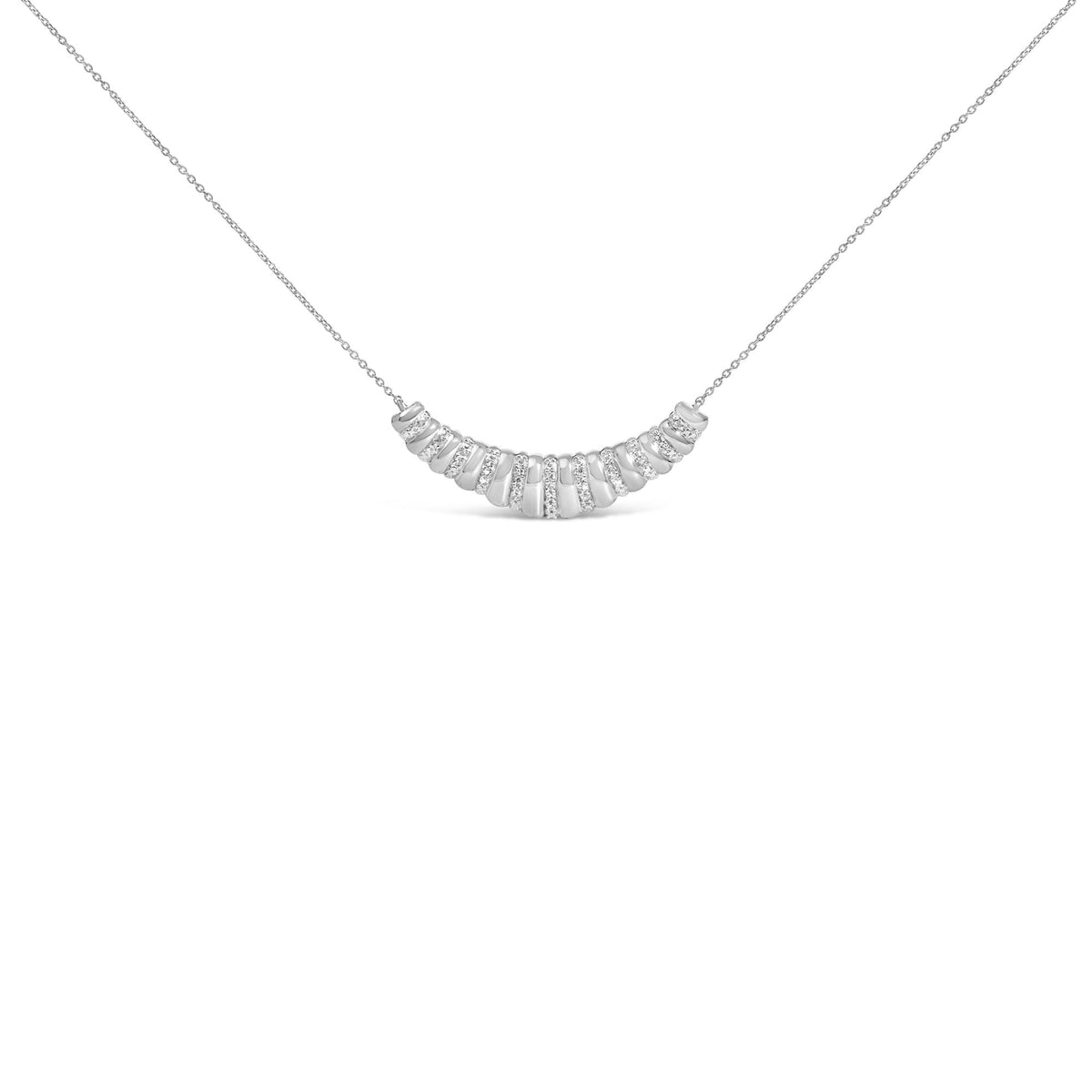 Close-up front view of a white metal necklace with an arc-shaped pendant featuring alternating sections of polished metal and white gemstones in a pave setting, shown against a white background.
