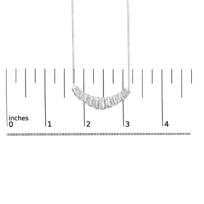 Close-up front view of a white necklace chain with a crescent-shaped pendant featuring alternating smooth segments and segments set with small white gemstones, shown on a measuring scale.