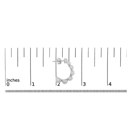 Close-up front angle of a single white metal hoop earring with round white gemstones in pave setting, shown on a scale.