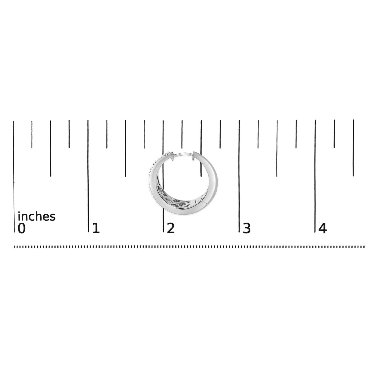 Close-up front angle view of a white metal hoop earring with round white gemstones set in a prong setting along one side, shown on a scale.