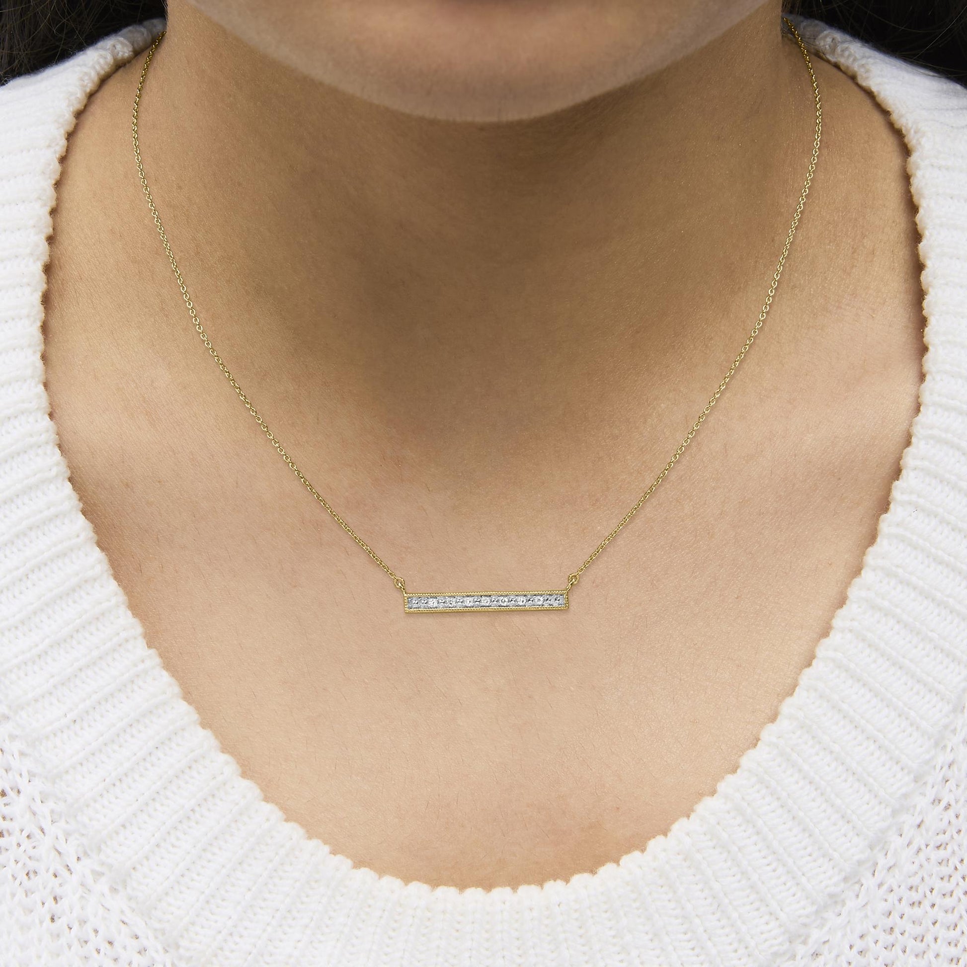 Yellow necklace with a horizontal rectangular pendant featuring a row of small white gemstones in prong settings, shown worn on a model from a close-up front angle.