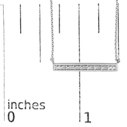 Close-up front view of a white metal bar necklace with a row of round white gemstones set in prongs, displayed on a measurement scale.