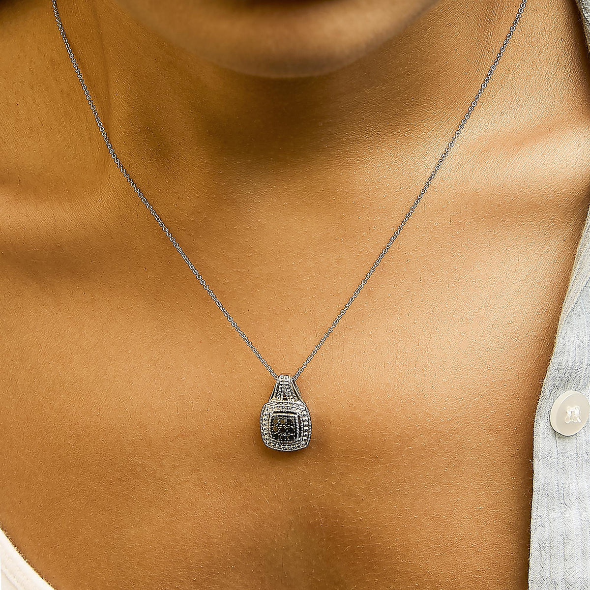Close-up front view of a necklace with a white chain and a pendant featuring black round gemstones in a pave setting, shown worn on a model.