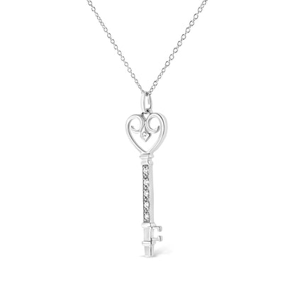 Front view of white metal key-shaped necklace pendant with a heart-shaped top featuring a bezel-set round brownish gemstone and a vertical bar decorated with several pave-set round brownish gemstones, displayed on a chain.