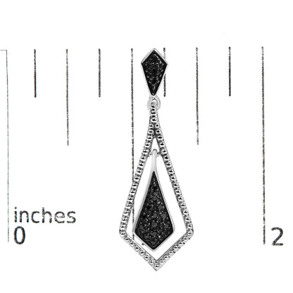 Close-up front view of a white-colored earring with black gemstones in pave setting, shown on a scale.