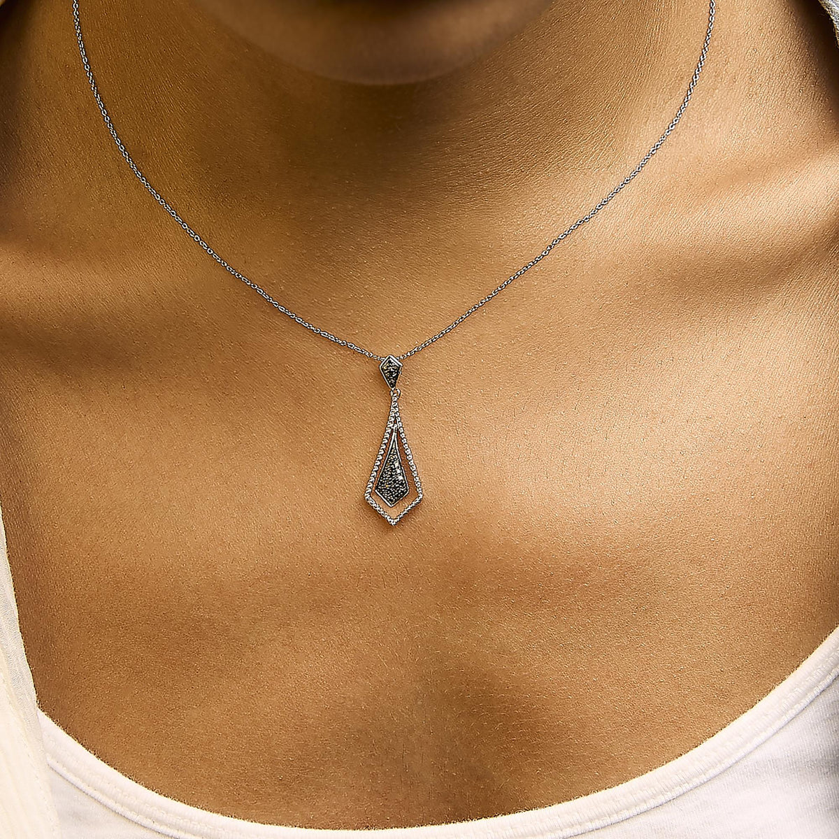 Close-up front view of a white metal necklace with black gemstones in pave setting on a model's neck. The necklace features a geometric pendant with two connected diamond-shaped sections.