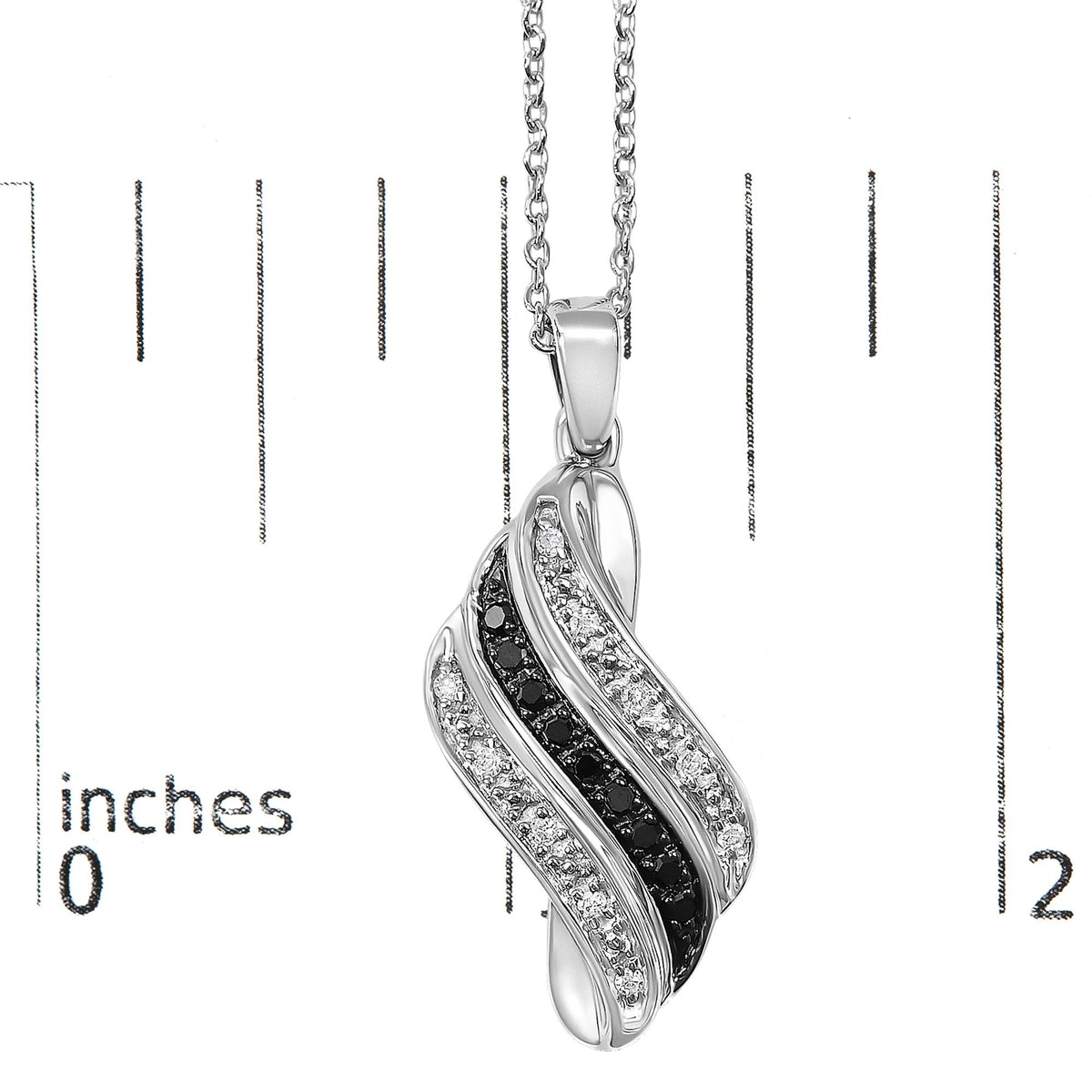 Close-up front view of a white metal necklace pendant with an intertwined design featuring pave set white gemstones and prong set black gemstones, shown on a scale.