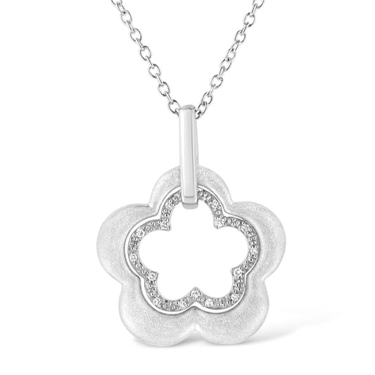 Front-facing shot of a white metal flower-shaped necklace pendant with a central cutout bordered by pave-set round white gemstones, hanging from a chain.