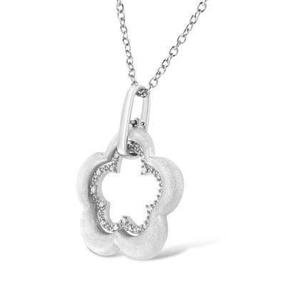 White metal necklace with a flower-shaped pendant featuring a pave setting of round white gemstones, shown in a close-up angled view.