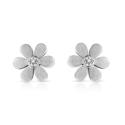 Pair of white metal flower-shaped earrings with textured petals and round white gemstones in the center, shown from a front angle on a white background.