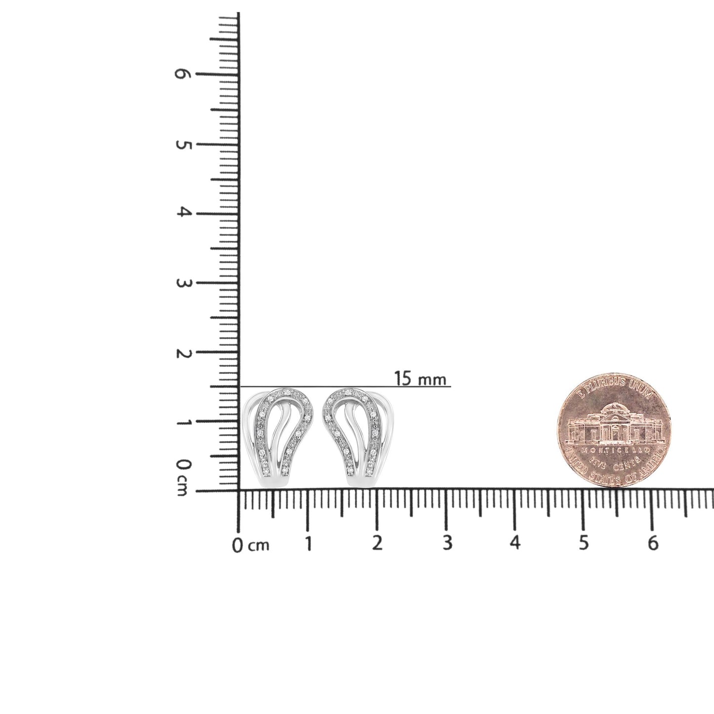 White metal earrings with curved design and pave set round white gemstones, shown from front on a ruler and next to a coin for size reference.