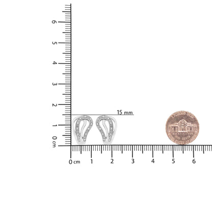 White metal earrings with curved design and pave set round white gemstones, shown from front on a ruler and next to a coin for size reference.