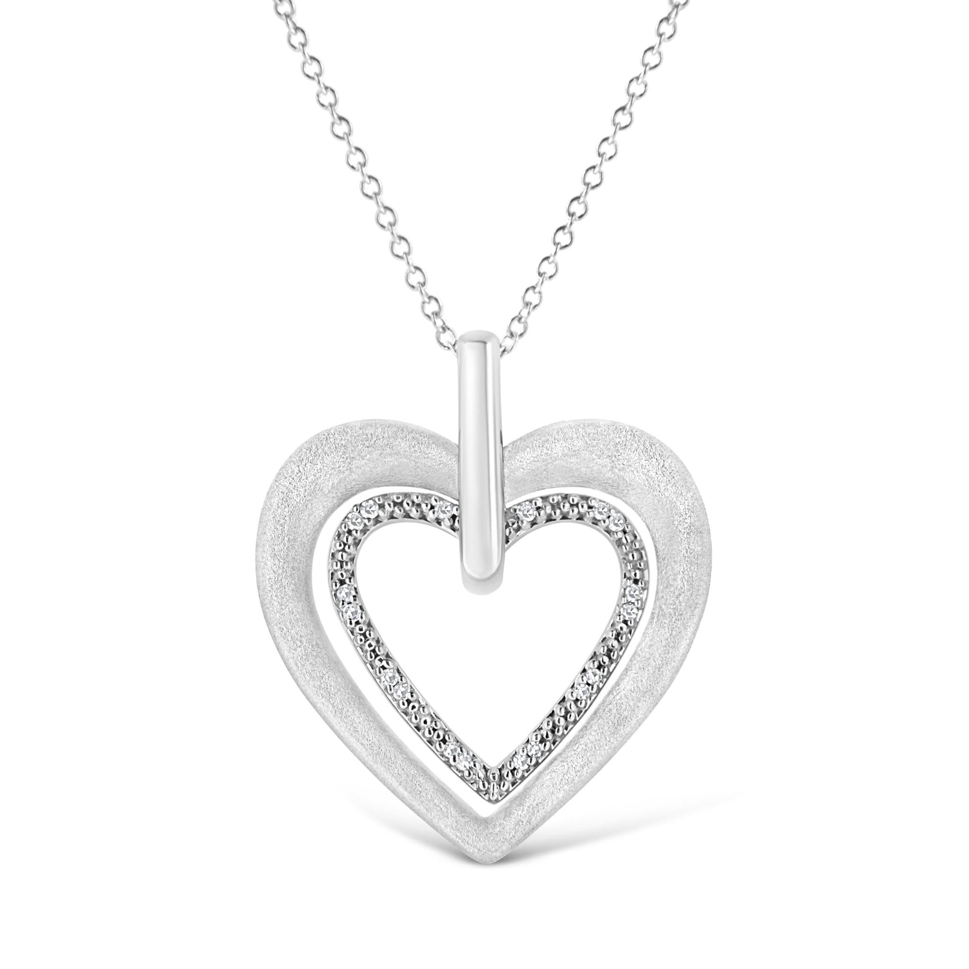 Front view of white metal heart-shaped necklace pendant with inner heart outlined by round white gemstones in prong settings.