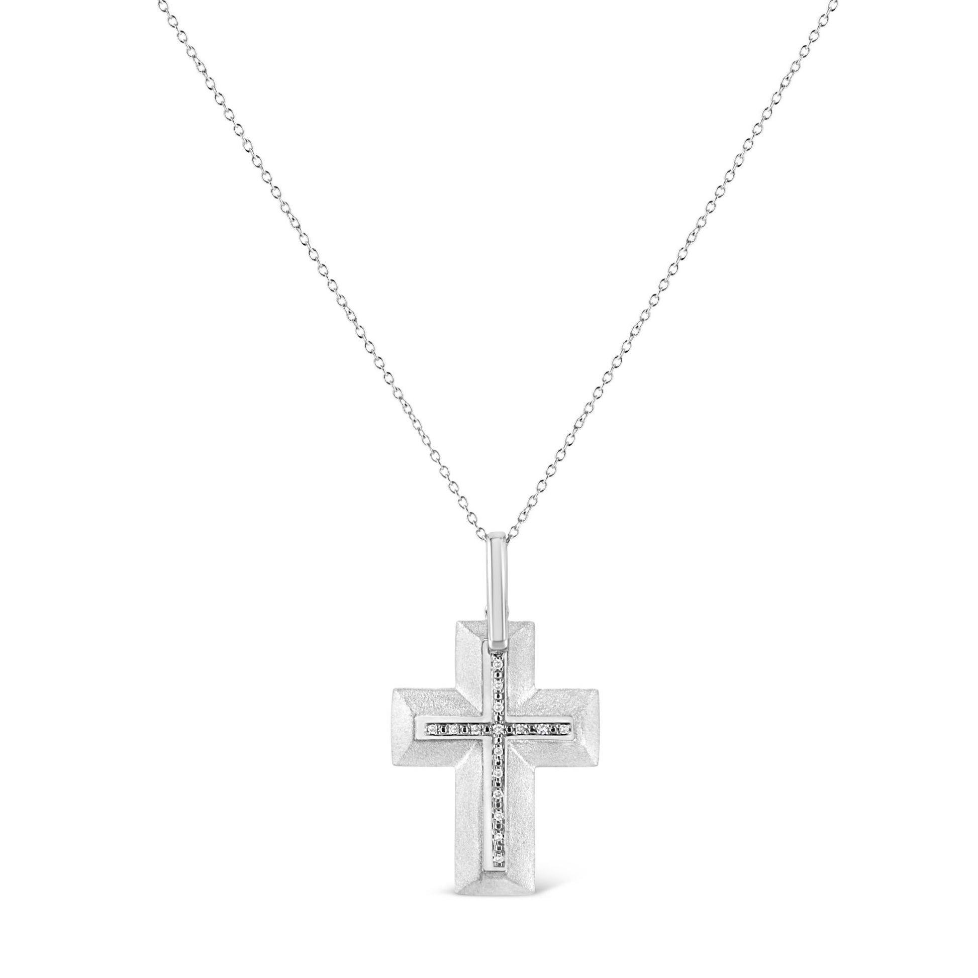 Front-facing shot of a white metal cross necklace with a smaller cross of white round prong-set gemstones in the center, hanging from a delicate white chain.