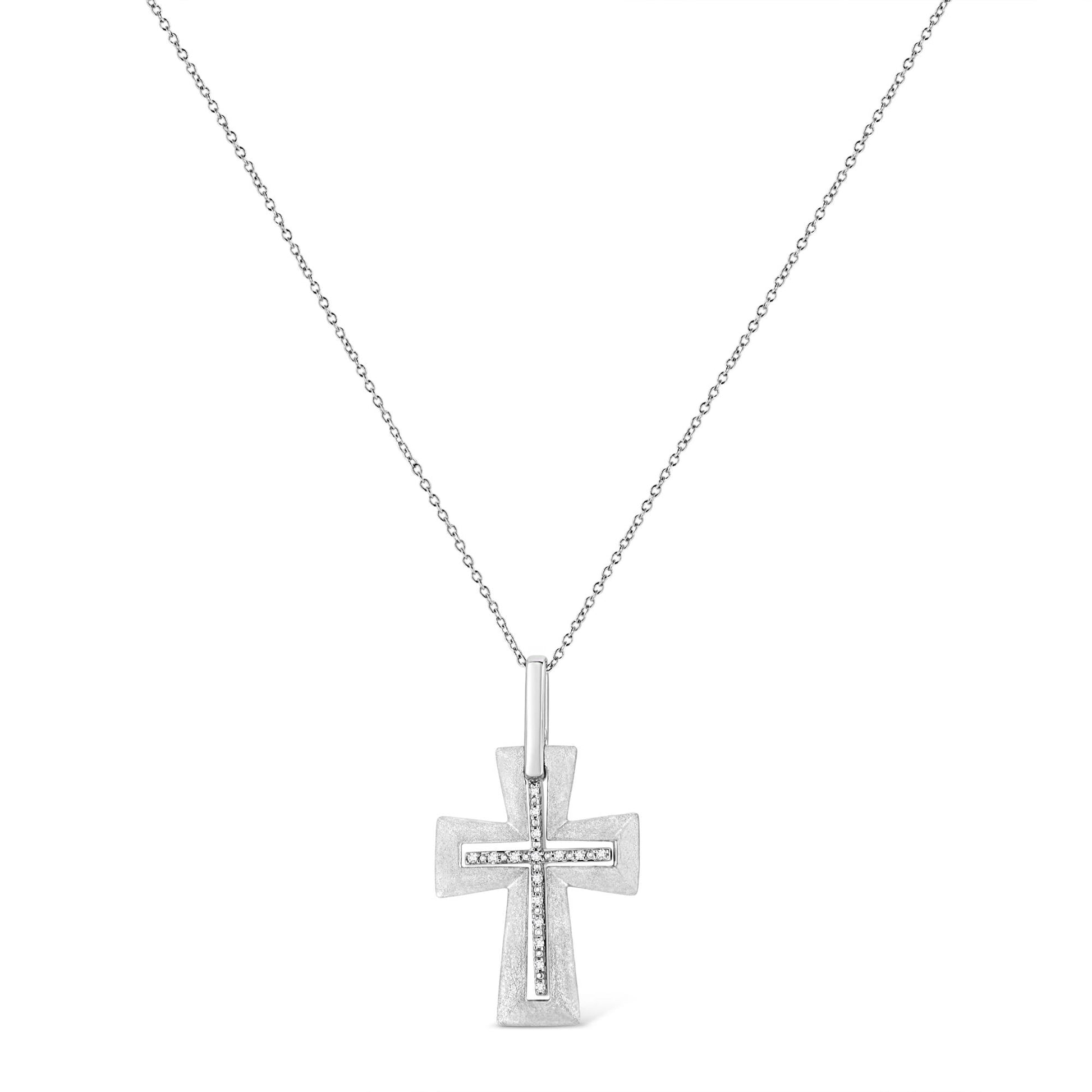Front-facing shot of a white metal cross necklace pendant featuring white round gemstones in prong settings along the center, hanging from a delicate chain.