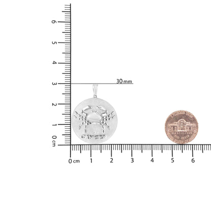 Round white metal pendant necklace with raised crab design and 'CANCER' text, featuring one small round brownish gemstone in bezel setting, shown flat on a ruler for size reference.