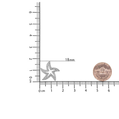 Top-down view of a white starfish-shaped necklace pendant with round white gemstones in prong settings, placed on a ruler for size reference.