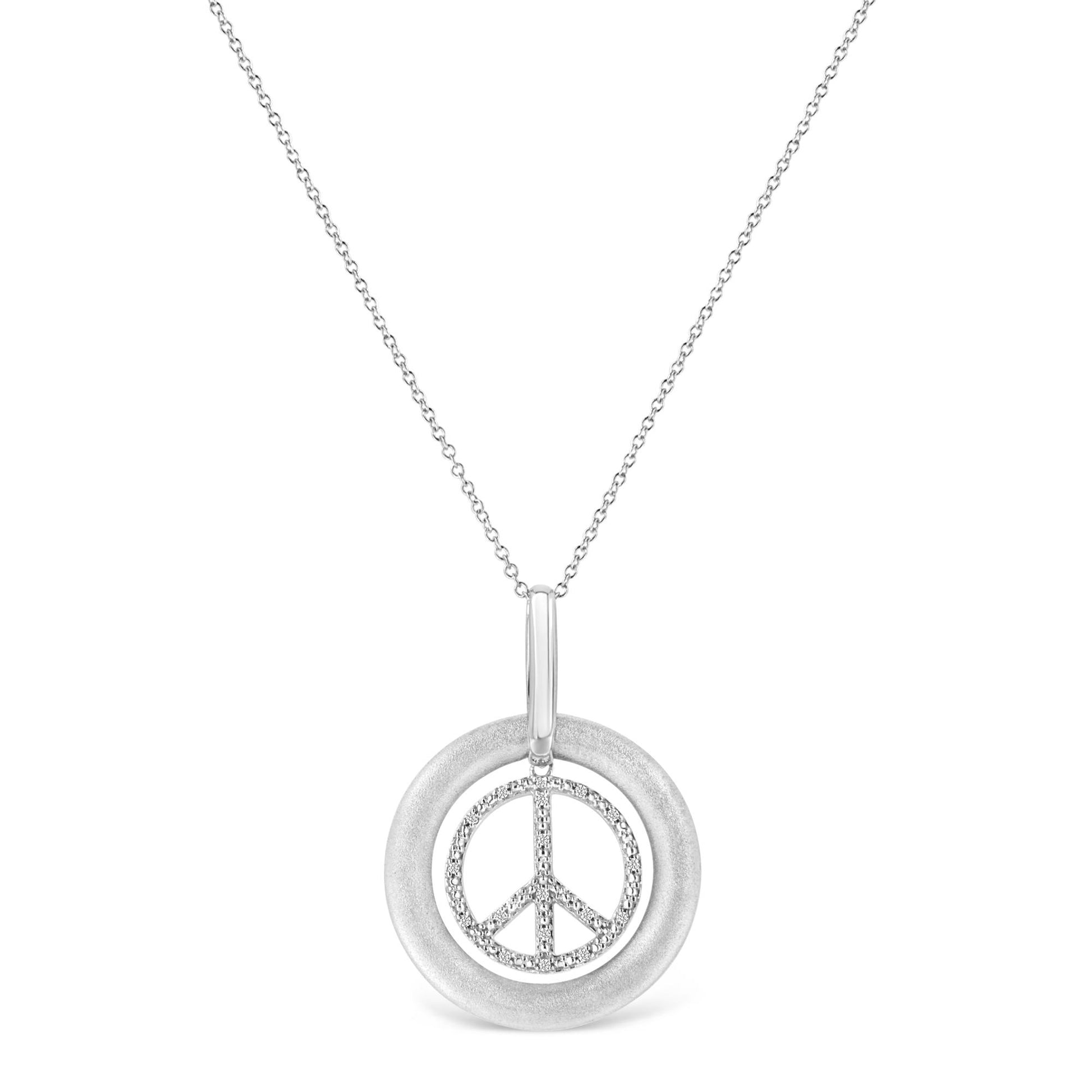 Front-facing shot of a white metal necklace with a pendant featuring a textured circular frame and an inner peace symbol adorned with round white gemstones in prong settings.