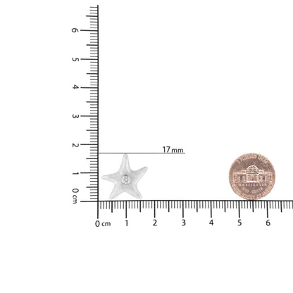 White star-shaped necklace pendant with a cluster of round white gemstones in the center, shown on a ruler for size reference, top-down angle.