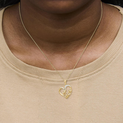 Close-up front view of a yellow metal necklace with a heart-shaped pendant featuring pave-set white gemstones, shown worn on a model.