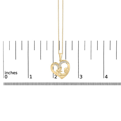Close-up front view of a yellow necklace pendant in the shape of a heart featuring two figures inside and accented with five white round gemstones in a pave setting, shown hanging on a chain against a ruler scale.