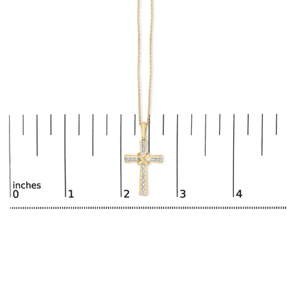 Close-up front view of a yellow necklace with a cross pendant featuring white gemstones in a pave setting, shown on a scale with inch markings.