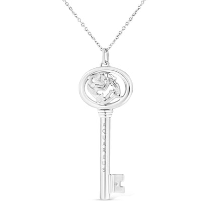 Front view of white metal key-shaped necklace pendant with Aquarius engraving and round bezel-set brownish gemstone near the teeth of the key.