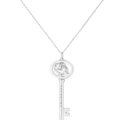 Front-facing shot of a white metal key-shaped necklace pendant with a round bezel-set brownish gemstone near the base and an Aquarius engraving on the vertical bar.