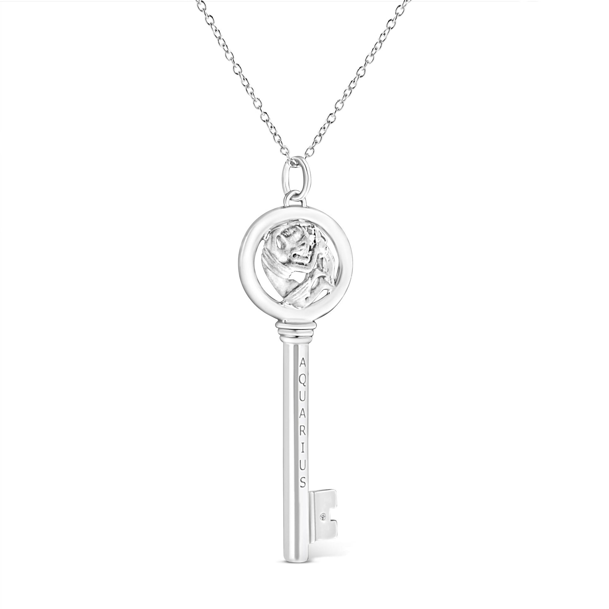 Front view of a white metal key-shaped necklace pendant with a round bezel-set brownish gemstone near the bottom and an Aquarius engraving on the stem.