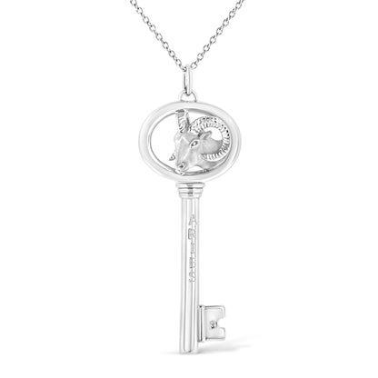 Front view of white metal key-shaped necklace pendant with ram head design and small brownish round gemstone in bezel setting near the base.
