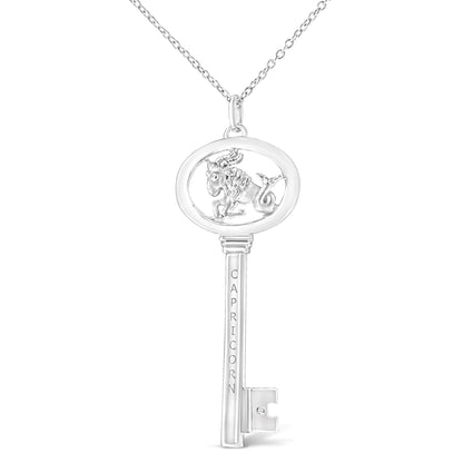 Front view of white metal key-shaped necklace pendant with Capricorn symbol and engraved text, featuring one round brownish bezel-set gemstone.