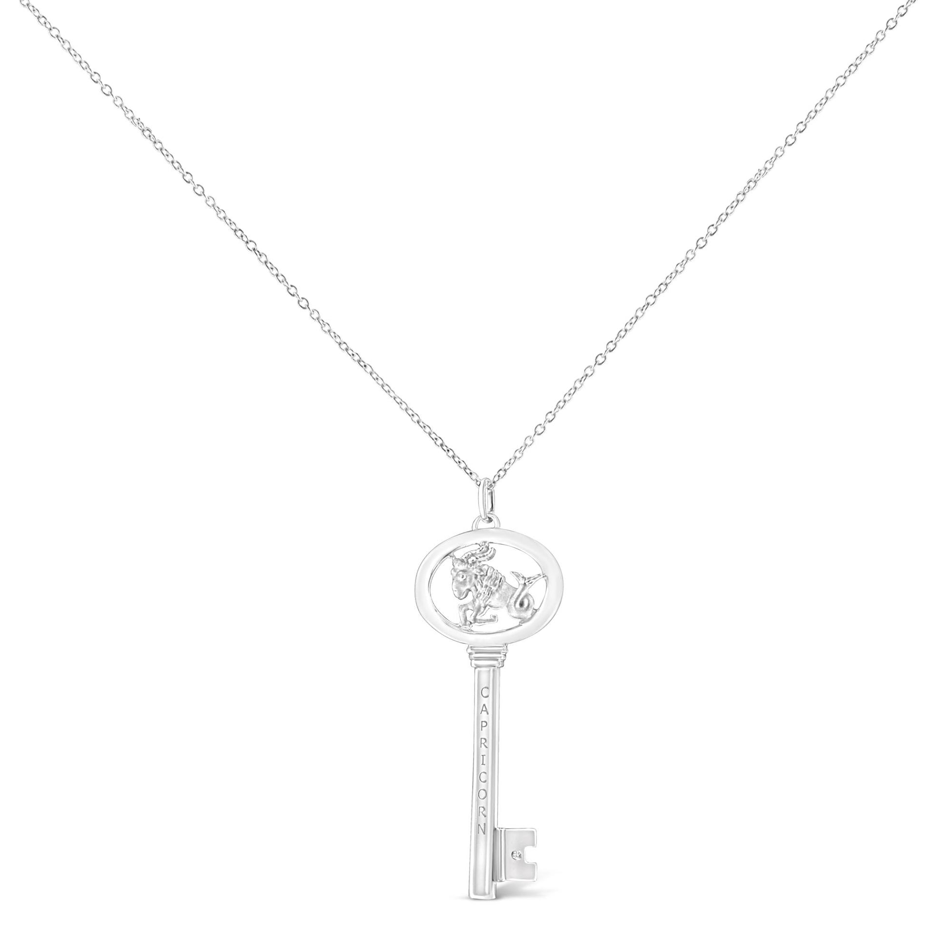 White metal necklace with a key pendant featuring a depiction of Capricorn in the oval top and a small brownish round gemstone in a bezel setting near the bottom, shown from the front.