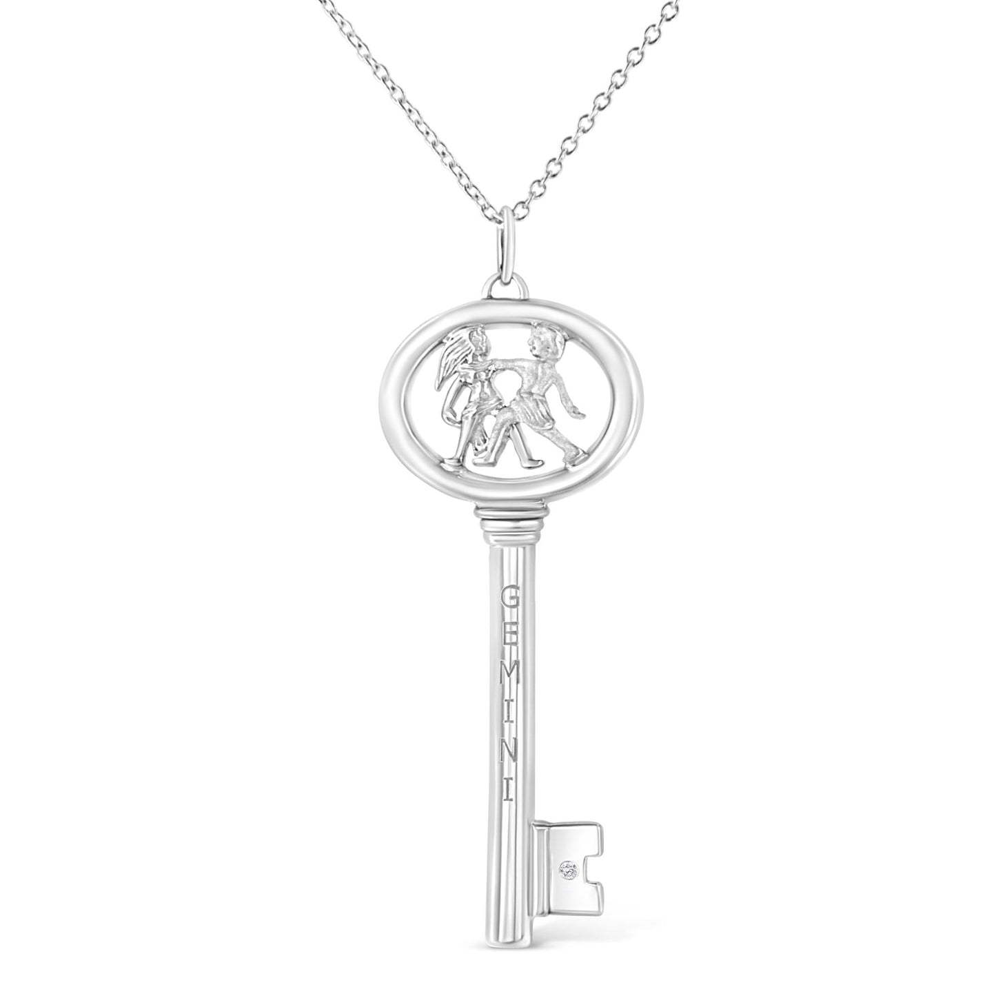 Front-facing white metal key-shaped necklace pendant with two children figures inside the oval top and a small round brownish gemstone in bezel setting on the key bit.