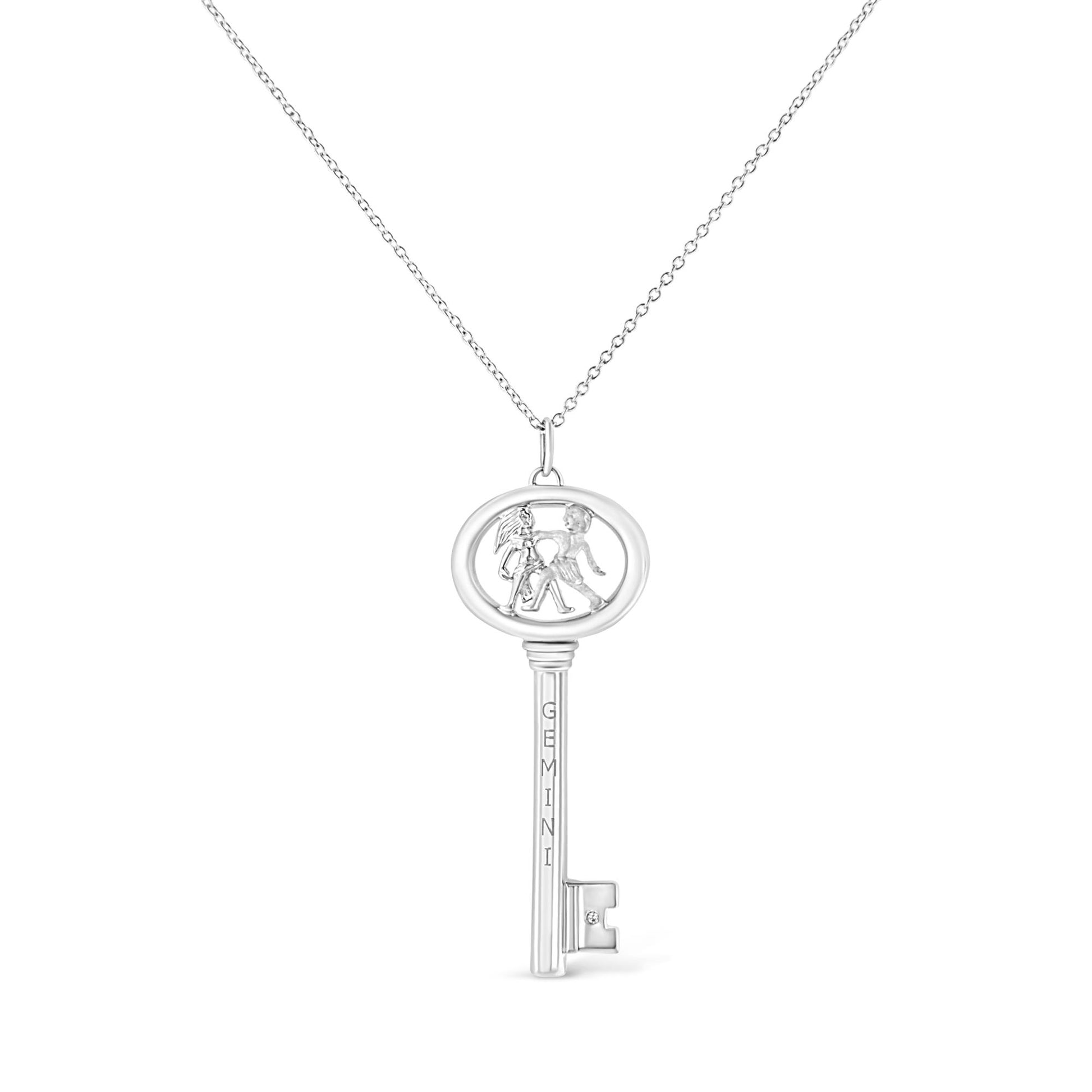 White metal key-shaped necklace pendant with two figures inside the oval top and a small round brownish gemstone set near the bottom, shown from the front.