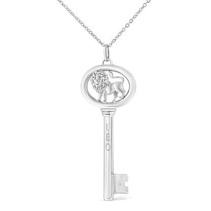 Front view of a white metal key-shaped necklace pendant with an oval top featuring a lion design and a small round brownish gemstone in a bezel setting near the bottom.