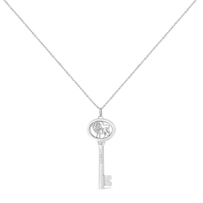 Front view of white metal key-shaped necklace pendant with a lion figure inside an oval frame and a round brownish gemstone in bezel setting, hanging from a fine chain.
